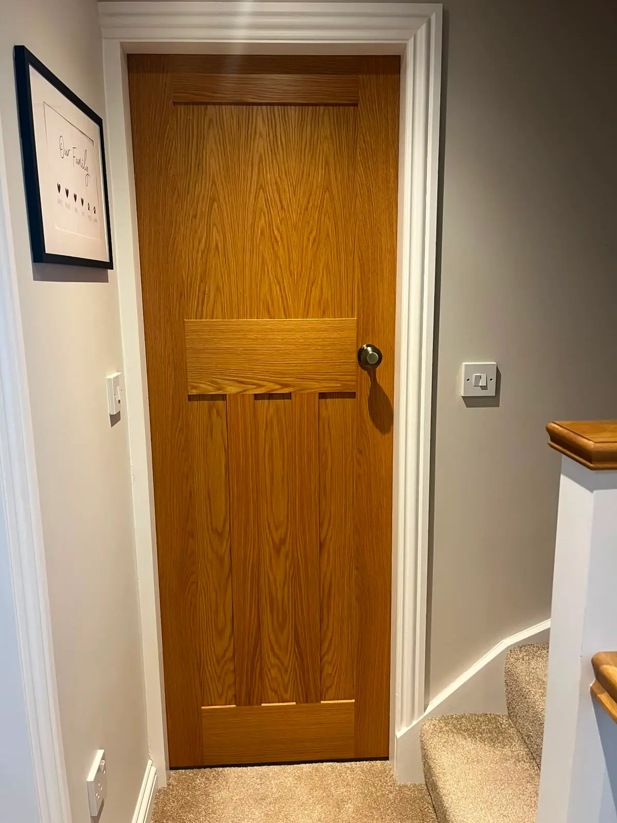 Oak panelled internal door hung in a white painted lining, with a brushed metal knob.