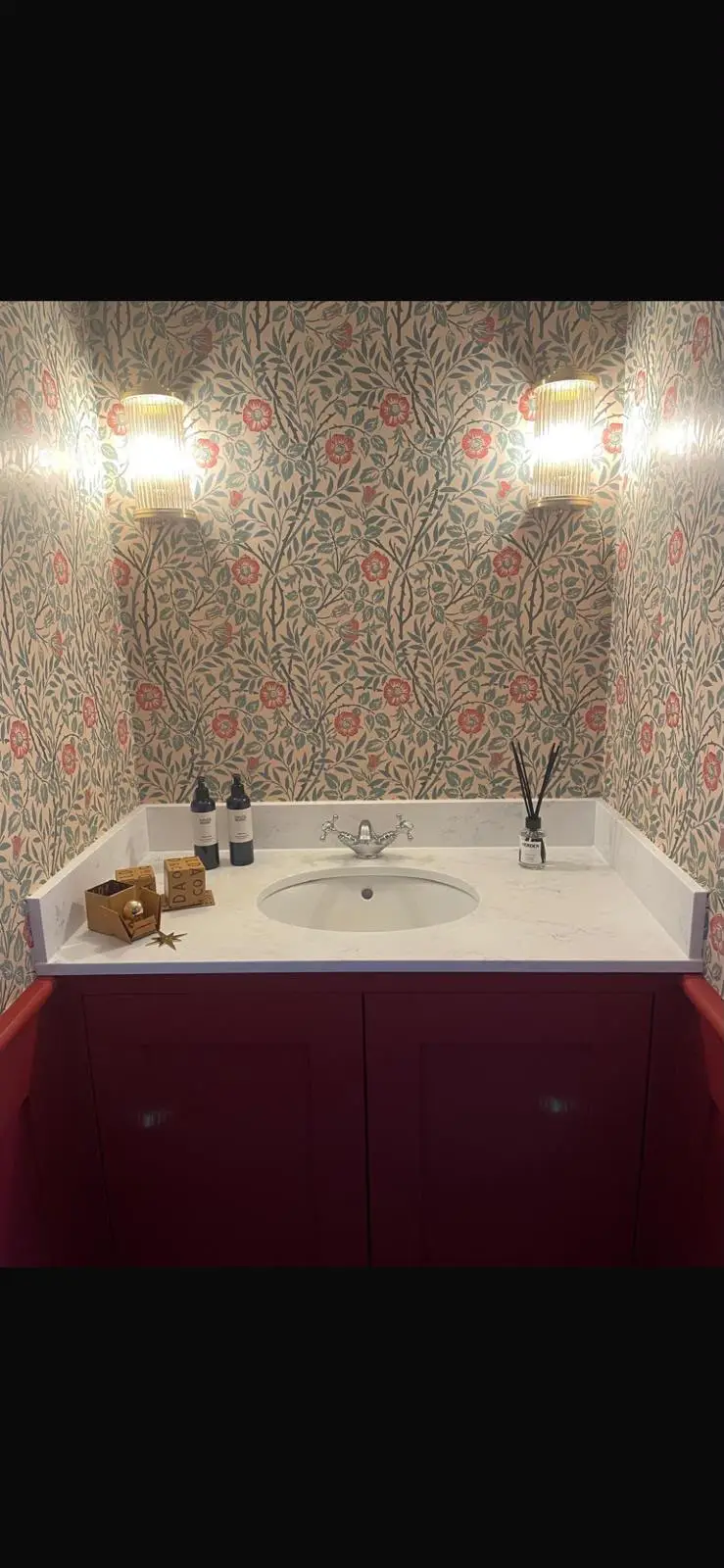 Fitted cloakroom vanity in deep red with shaker doors, under a marble-effect top with an upstand and an inset basin.